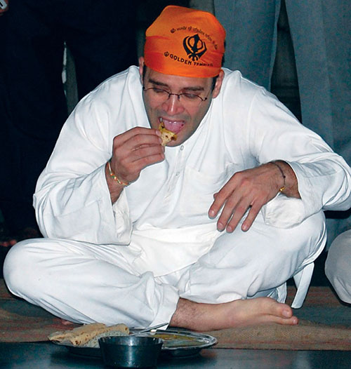 Rahul Gandhi eats at a community kitchen after paying homage at the Golden temple, the holiest Sikh shrine, in Amritsar
